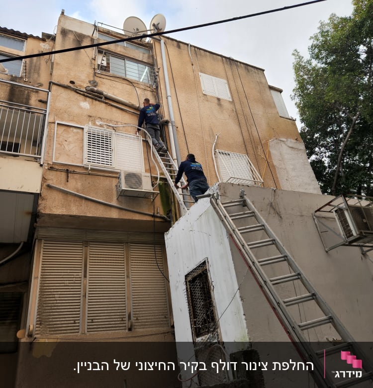 שני אנשים על סולמות מתקנים צינורות חיצוניים